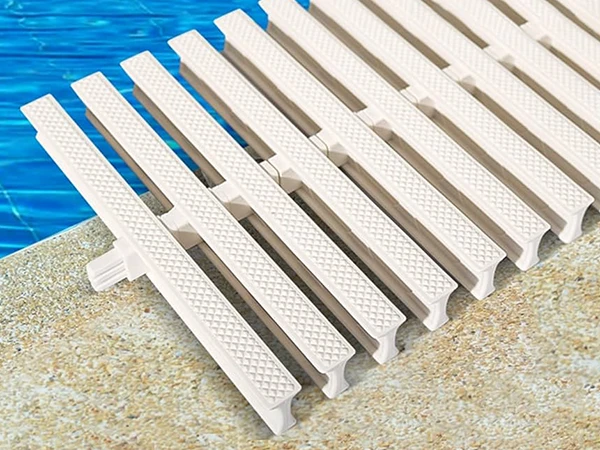 A gutter grating is placed next to the swimming pool.